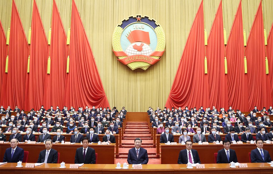 시진핑(習近平), 리커창(李克強), 리잔수(栗戰書), 왕후닝(王滬寧), 자오러지(趙樂際), 한정(韓正), 왕치산(王岐山)이 연단에 앉아 있고 왕양(汪洋)이 정협 제13기 전국위원회 상무위원회를 대표해 대회 업무 보고를 하고 있다. [사진 출처: 신화사]